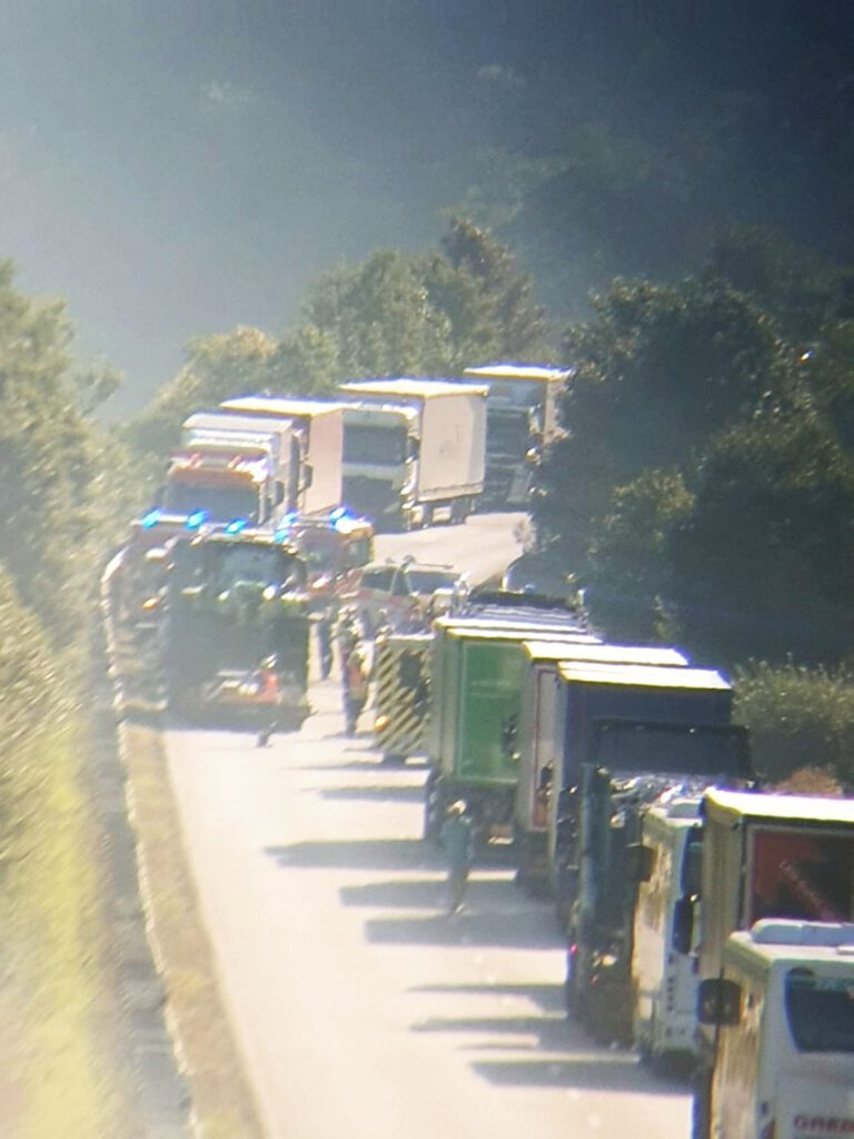 Unfallszenerie und sich stauende Fahrzeuge auf der Bundesstraße