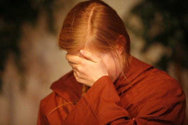 Verzweifelte Frau schlägt Hand vors Gesicht