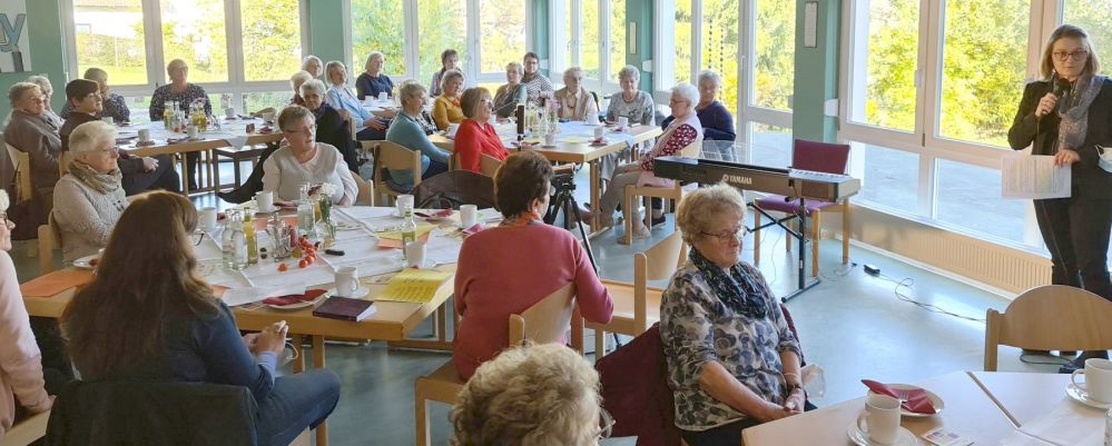 Frauen an Tischen und eine Referentin