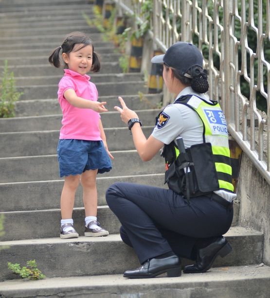 Polizistin und kleines Kind auf einer Treppe