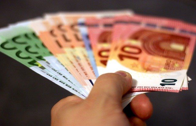 Hand hält Geldscheine hin