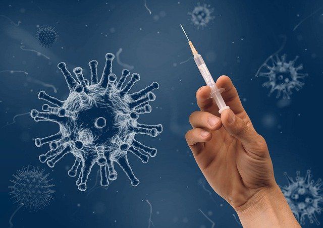 Virus und davor Hand mit Spritze