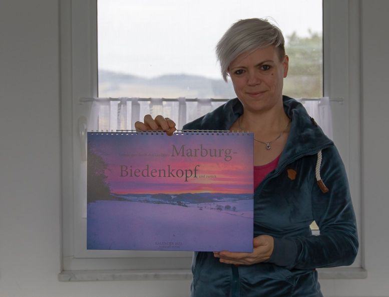 Frau hält einen Kalender mit Naturmotiv