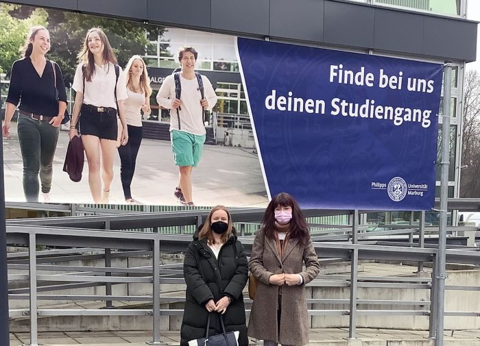 2 Schülerinnen vor einem Studien-Werbeplakat
