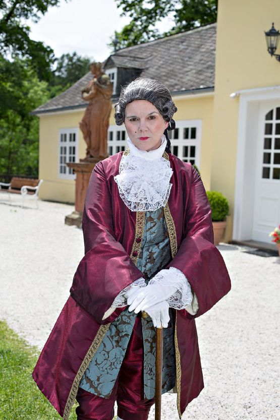 Barock gekleidete Person vor dem Schloss