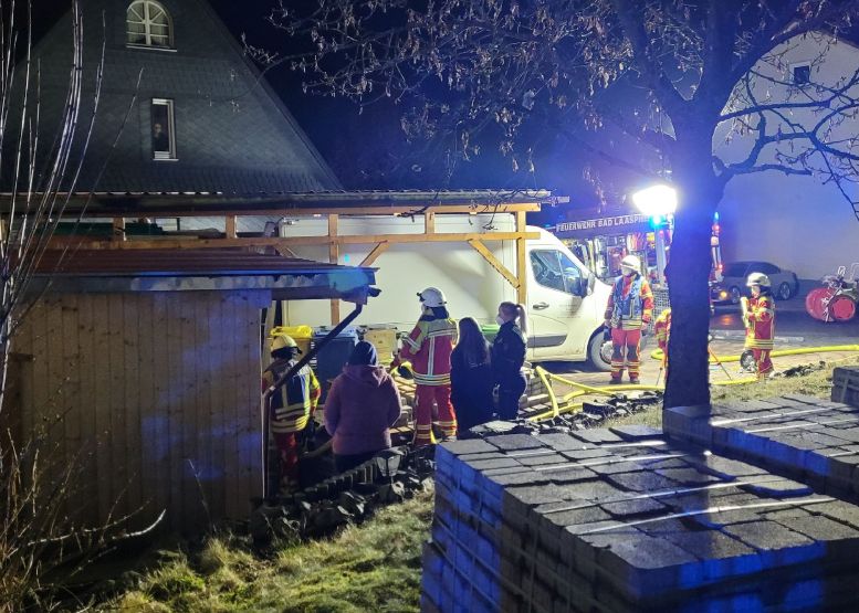 Feuerwehrleute löschen an einem Carport