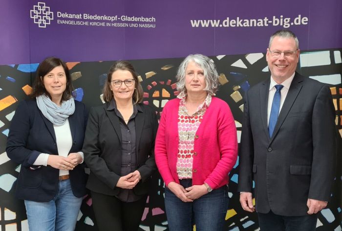 3 Frauen ein Mann vor dem Dekanats-Plakat