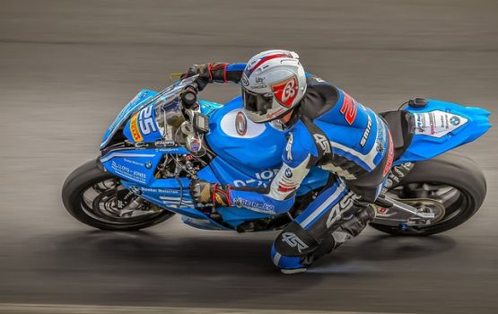 Biker schnell in der Kurve auf blauer Maschine