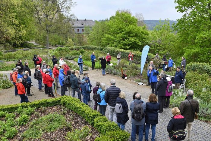 Leute in Wanderkluft stehen in einem Park herum
