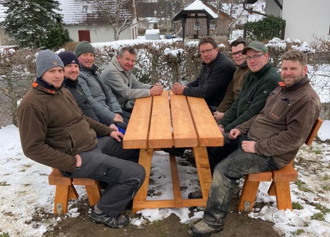 8 Männer an der neuen Sitzgruppe - 2 Bänke und 1 Tisch