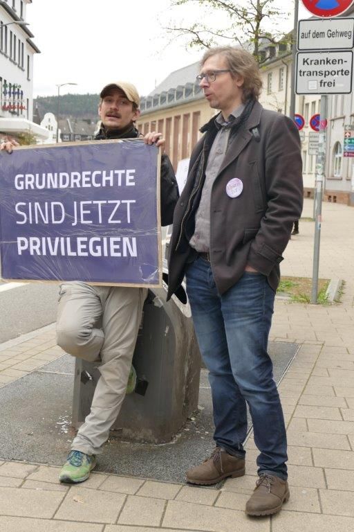 2 Männer mit Schild: "Grundrechte sind jetzt Privilegien"