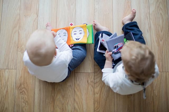 2 Kleinkinder spielen am Boden