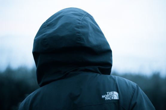 Person mit dunkler Markenjacke von hinten